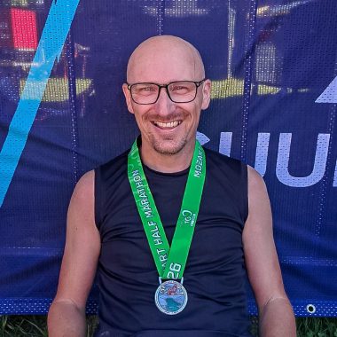 Alfred lächelnd mit der Finisher-Medaille vom Mozart Halbmarathon 2026